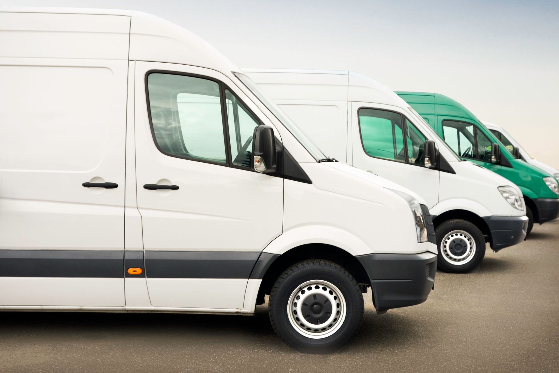 Group of white service vehicles parked outdoors